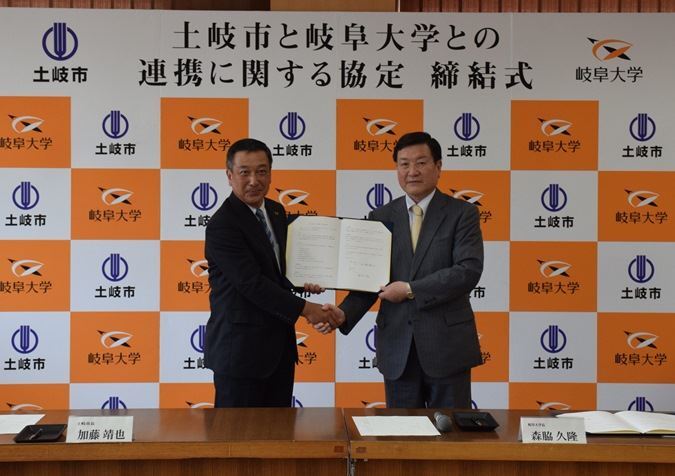 写真:協定書を手に握手を交わす加藤土岐市長と森脇岐阜大学学長